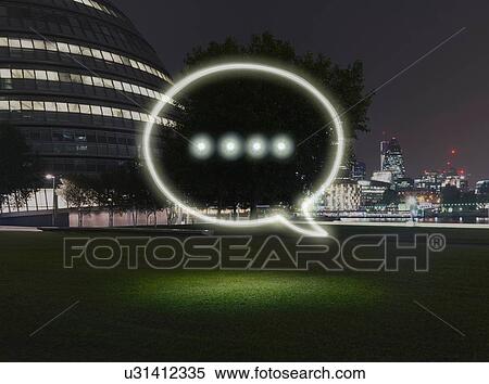 Stock Photography - Glowing speech bubble symbol in city at night. Fotosearch