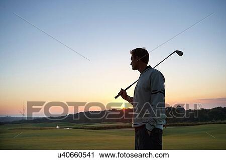 Golfer carrying golf club over shoulder looking at sunset View Large Photo Image Stock Image - Golfer carrying golf club over shoulder looking at sunset. Fotosearch