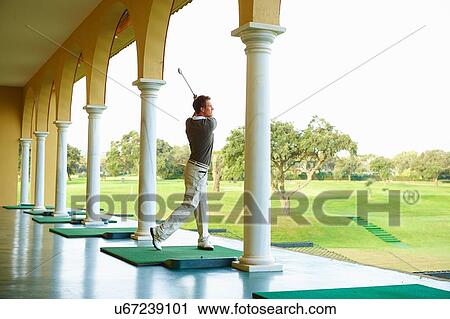 Golfer in archways practising golf swing looking away View Large Photo Image Stock Image - Golfer in archways practising golf swing looking away. Fotosearch