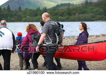Group of people taking canoe out on lake, Cumbria, UK View Large Photo Image Stock Image - Group of people taking canoe out on lake, Cumbria, UK. Fotosearch