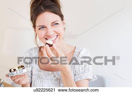 Head and shoulders of mature woman holding sweet baked goods, looking away smiling View Large Photo Image Stock Image - Head and shoulders of mature woman holding sweet baked goods, looking away smiling. Fotosearch
