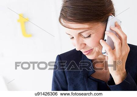 Head and shoulders of mature woman using smartphone, looking down smiling View Large Photo Image Stock Photograph - Head and shoulders of mature woman using smartphone, looking down smiling. Fotosearch