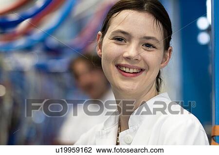 Head and shoulders of your woman wearing lab coat looking at camera smiling View Large Photo Image Stock Image - Head and shoulders of your woman wearing lab coat looking at camera smiling. Fotosearch