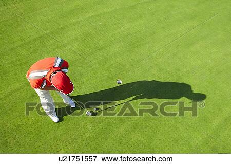 Stock Photo - High view of golfer and shadow putting. Fotosearch