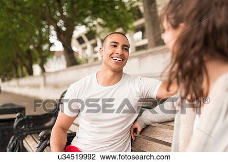 Male and female city runners chatting on bench View Large Photo Image Stock Image - Male and female city runners chatting on bench. Fotosearch