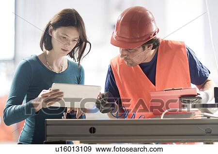 Male and female colleagues in industrial occupation using digital tablet View Large Photo Image Stock Photo - Male and female colleagues in industrial occupation using digital tablet. Fotosearch