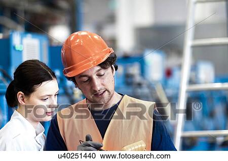 Male and female colleagues looking down discussing work View Large Photo Image Stock Image - Male and female colleagues looking down discussing work. Fotosearch