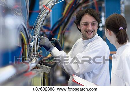Male and female colleagues wearing lab coats, face to face smiling View Large Photo Image Stock Photo - Male and female colleagues wearing lab coats, face to face smiling. Fotosearch