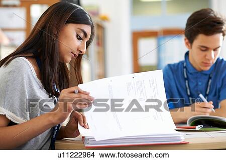Picture - Male and female student working on files in class. Fotosearch