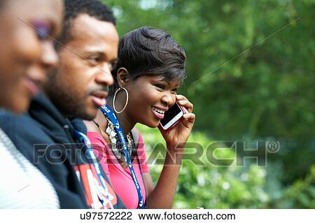 Male and female students on college campus talking on smartphone View Large Photo Image Stock Image - Male and female students on college campus talking on smartphone. Fotosearch