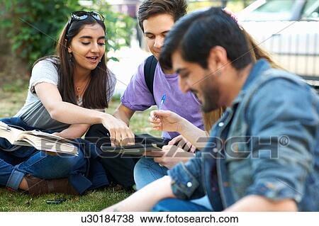 Male and female students sitting chatting and working on college campus View Large Photo Image Stock Photo - Male and female students sitting chatting and working on college campus. Fotosearch