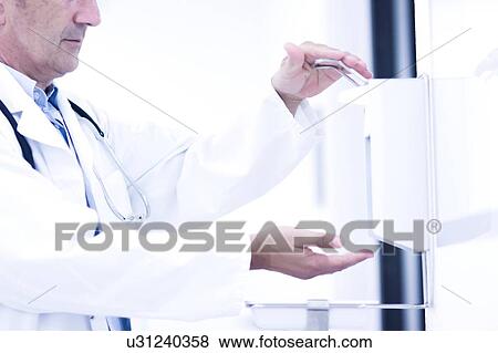 Male doctor using hand santizer View Large Photo Image Stock Photo - Male doctor using hand santizer. Fotosearch
