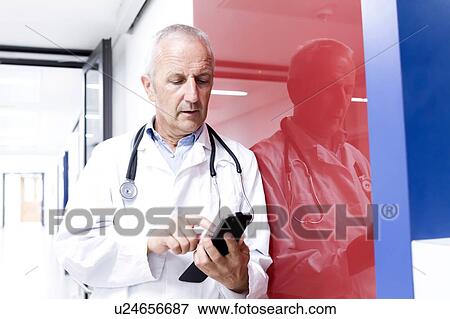 Stock Photo - Male doctor using smartphone. Fotosearch