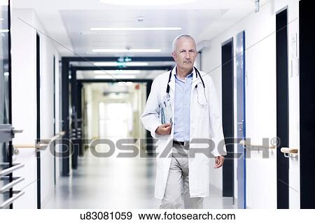 Stock Photo - Male doctor walking along corridor. Fotosearch