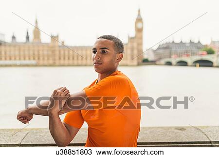 Stock Image - Male runner preparing on Southbank, London, UK. Fotosearch