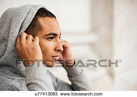 Male runner wearing grey hoody putting in earphones View Large Photo Image Stock Image - Male runner wearing grey hoody putting in earphones. Fotosearch