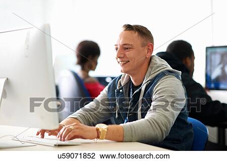 Male student typing on desktop computer in classroom View Large Photo Image Stock Image - Male student typing on desktop computer in classroom. Fotosearch