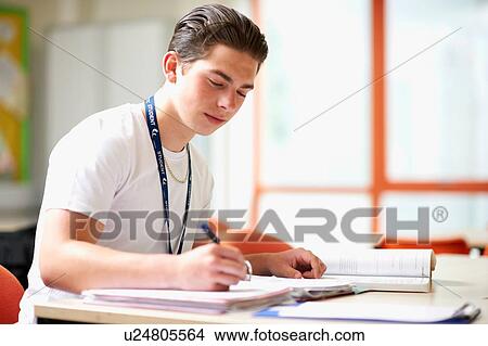 Male teenage student writing in file View Large Photo Image Picture - Male teenage student writing in file. Fotosearch