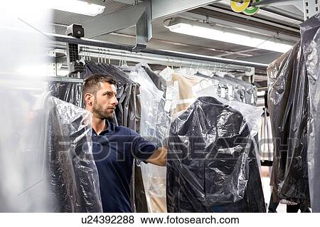 Male warehouse worker doing garment stock take in distribution warehouse View Large Photo Image Stock Photo - Male warehouse worker doing garment stock take in distribution warehouse. Fotosearch