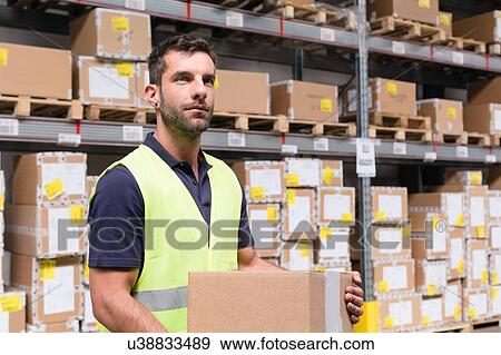 Stock Photo - Male warehouse worker preparing order in distribution warehouse. Fotosearch