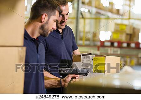 Stock Photo - Male warehouse workers using barcode scanner in distribution warehouse. Fotosearch