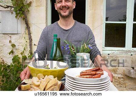 Man carrying tray of food outside house View Large Photo Image Stock Photography - Man carrying tray of food outside house. Fotosearch