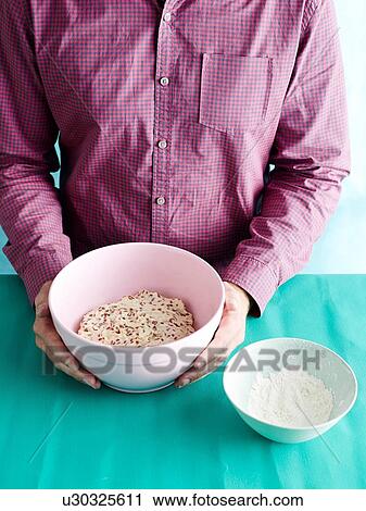Stock Image - Man preparing unkneaded bread recipe step 1, bread dough. Fotosearch
