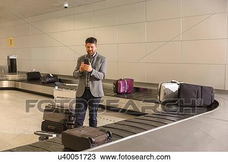 Man waiting for luggage at baggage claim area in airport View Large Photo Image Stock Image - Man waiting for luggage at baggage claim area in airport. Fotosearch