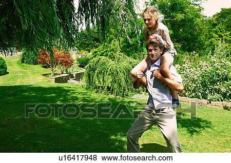 Mature man running with daughter on his shoulders in garden View Large Photo Image Stock Photo - Mature man running with daughter on his shoulders in garden. Fotosearch