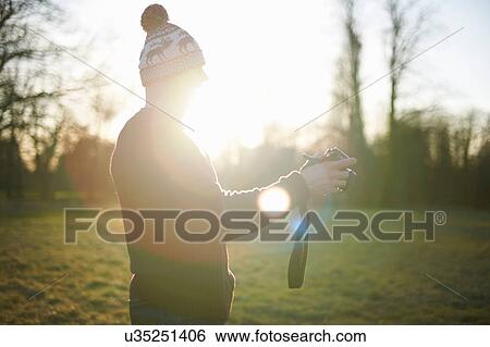 Stock Photograph - Mature man using camera outdoors. Fotosearch