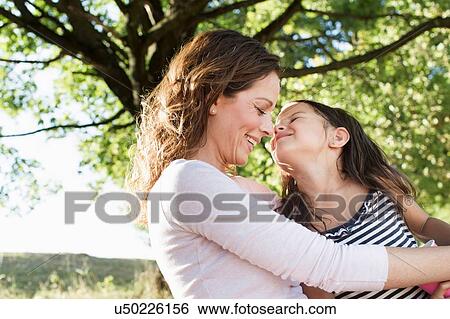 Stock Photograph - Mature woman and daughter in park. Fotosearch