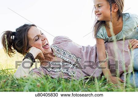 Mature woman and daughter laughing and playing in park View Large Photo Image Stock Image - Mature woman and daughter laughing and playing in park. Fotosearch