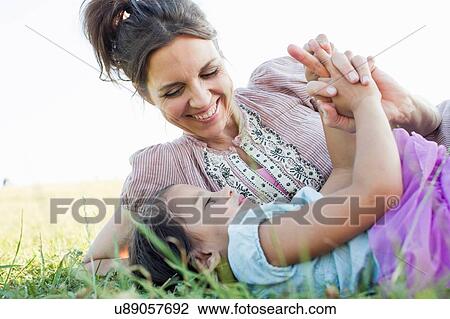 Mature woman and daughter reclining holding hands in park View Large Photo Image Stock Image - Mature woman and daughter reclining holding hands in park. Fotosearch