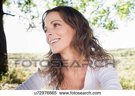 Stock Photography - Mature woman sitting in park. Fotosearch