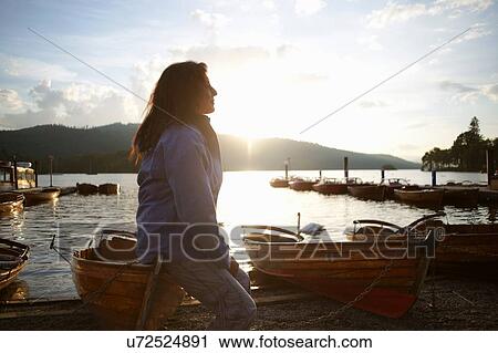Mature woman sitting on canoe by lake, Lake District, Cumbria, UK View Large Photo Image Stock Image - Mature woman sitting on canoe by lake, Lake District, Cumbria, UK. Fotosearch