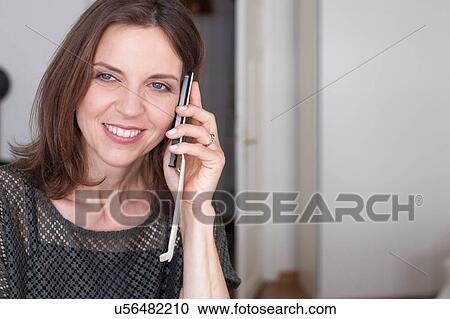 Mature woman using smartphone in phone case looking away smiling View Large Photo Image Stock Image - Mature woman using smartphone in phone case looking away smiling. Fotosearch