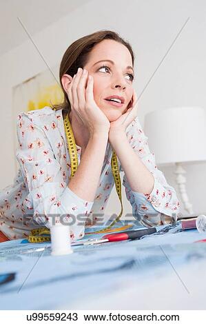 Mature woman with tape measure resting on elbows, chin on hands looking away View Large Photo Image Stock Image - Mature woman with tape measure resting on elbows, chin on hands looking away. Fotosearch