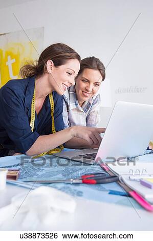 Mature women with tape measure resting on elbows using laptop smiling View Large Photo Image Stock Photograph - Mature women with tape measure resting on elbows using laptop smiling. Fotosearch