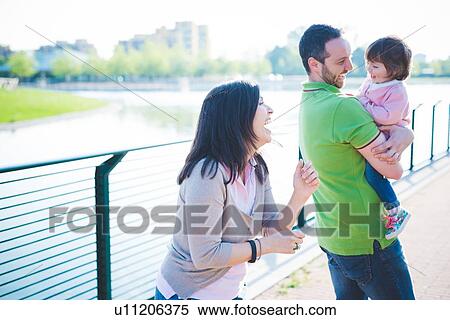 Mid adult couple with toddler daughter at riverside View Large Photo Image Stock Photography - Mid adult couple with toddler daughter at riverside. Fotosearch