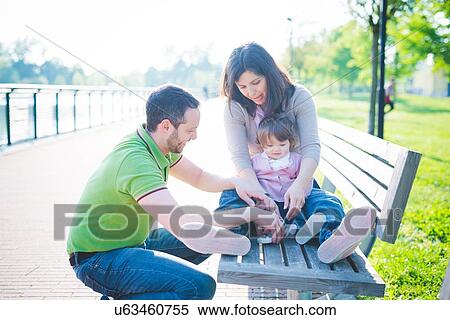 Mid adult couple with toddler daughter on park bench View Large Photo Image Stock Photography - Mid adult couple with toddler daughter on park bench. Fotosearch