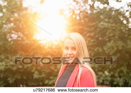Stock Photograph - Mid adult long haired blonde woman in sunlight looking at camera. Fotosearch