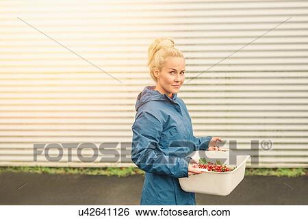 Mid adult woman holding container of redcurrants, outdoors View Large Photo Image Stock Photograph - Mid adult woman holding container of redcurrants, outdoors. Fotosearch
