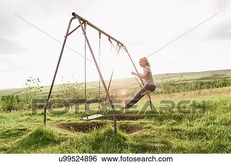 Mid adult woman, in field, swinging on swing View Large Photo Image Stock Photograph - Mid adult woman, in field, swinging on swing. Fotosearch