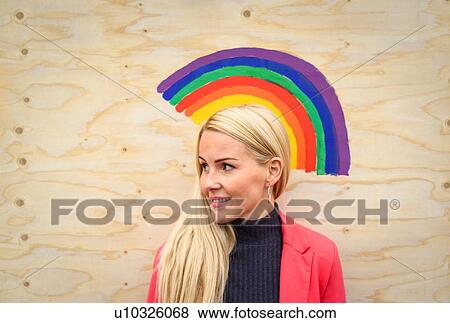 Mid adult woman in front of rainbow painted on plywood looking away View Large Photo Image Stock Photo - Mid adult woman in front of rainbow painted on plywood looking away. Fotosearch