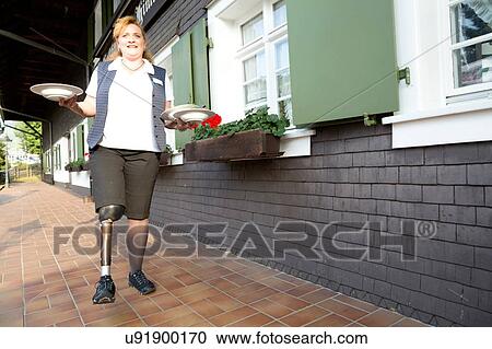 Mid adult woman with prosthetic leg, carrying plates, outdoors View Large Photo Image Stock Image - Mid adult woman with prosthetic leg, carrying plates, outdoors. Fotosearch
