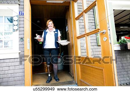 Mid adult woman with prosthetic leg, standing in doorway holding plates View Large Photo Image Stock Photo - Mid adult woman with prosthetic leg, standing in doorway holding plates. Fotosearch