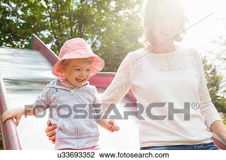 Mother and female toddler on park slide View Large Photo Image Stock Image - Mother and female toddler on park slide. Fotosearch