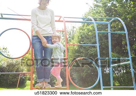 Mother and female toddler playing on climbing frame View Large Photo Image Stock Image - Mother and female toddler playing on climbing frame. Fotosearch