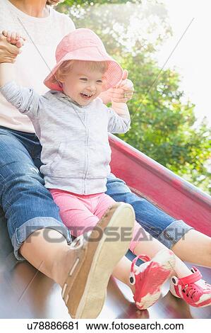 Mother and female toddler sliding on park slide View Large Photo Image Stock Image - Mother and female toddler sliding on park slide. Fotosearch