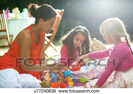 Mother and two girls playing picnics at garden birthday party View Large Photo Image Stock Photo - Mother and two girls playing picnics at garden birthday party. Fotosearch